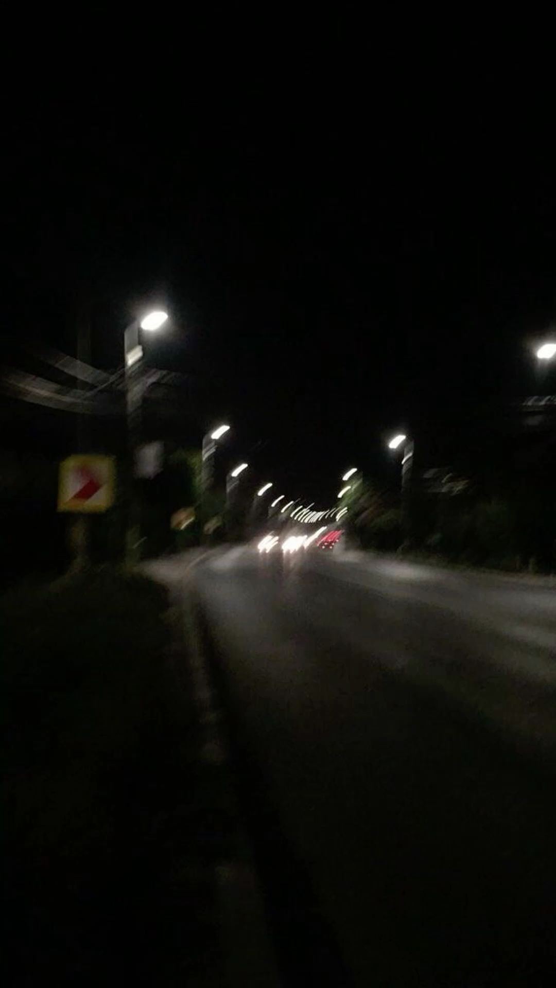 motion blurred night road with streaks of headlights and streetlamps
